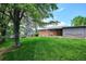 Spacious backyard with mature trees, lush green grass, and covered patio at 8490 E Davies Pl, Centennial, CO 80112