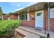 Close-up of the front door, showing the brick facade, shutters, and landscaped entryway at 8490 E Davies Pl, Centennial, CO 80112