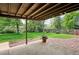Under deck patio overlooking the backyard with beautiful green grass and mature trees at 8490 E Davies Pl, Centennial, CO 80112