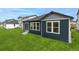 Backyard view of home featuring a well-manicured lawn, ample windows, and a sliding glass door at 13342 E 110Th Way, Commerce City, CO 80022