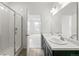 Bright bathroom with a double sink vanity, tiled shower and view into an adjacent room at 13342 E 110Th Way, Commerce City, CO 80022