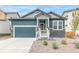 Charming blue two-story home with stone accents, a two-car garage, and well-maintained landscaping at 13342 E 110Th Way, Commerce City, CO 80022
