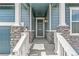 Inviting front porch featuring stone pillars, a modern entry door, and charming lantern-style lighting at 13342 E 110Th Way, Commerce City, CO 80022