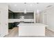 Modern kitchen features dark cabinets, a center island with a sink, and stainless steel appliances at 13342 E 110Th Way, Commerce City, CO 80022