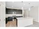 Bright kitchen with dark cabinetry, stainless steel appliances, pendant lights, and a white island at 13342 E 110Th Way, Commerce City, CO 80022
