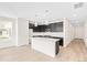 Modern kitchen features dark cabinets, a center island with a sink, and stainless steel appliances at 13342 E 110Th Way, Commerce City, CO 80022