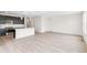 Modern open-concept living space with light wood floors connecting the living room and kitchen at 13342 E 110Th Way, Commerce City, CO 80022