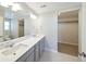 Bathroom featuring double sinks, large mirror, and spacious walk-in closet at 21854 E 9Th Pl, Aurora, CO 80018