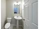 Bathroom featuring a pedestal sink, a toilet, neutral wall color and a decorative mirror at 21854 E 9Th Pl, Aurora, CO 80018