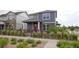 Inviting two-story home with gray siding, stone accents, a red front door and landscaped front yard with shrubs at 21854 E 9Th Pl, Aurora, CO 80018