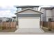 Attached two-car garage showcasing neutral siding and stone details on a modern home exterior at 21854 E 9Th Pl, Aurora, CO 80018