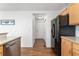 Kitchen hallway with wood flooring and access to pantry and garage at 447 Woodson Dr, Erie, CO 80516