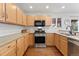 Well-lit kitchen featuring stainless steel appliances and light wood cabinets at 447 Woodson Dr, Erie, CO 80516