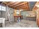 Unfinished basement featuring exposed wood beams, concrete walls, and a utility sink at 6737 Lee St, Arvada, CO 80004