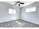 Cozy bedroom featuring a ceiling fan, two windows, and modern carpet at 6737 Lee St, Arvada, CO 80004