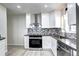 Well-equipped kitchen with stainless steel oven, stylish backsplash, and light wood floors at 6737 Lee St, Arvada, CO 80004