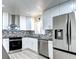 Modern kitchen featuring stainless steel appliances, white cabinets, and stylish backsplash at 6737 Lee St, Arvada, CO 80004