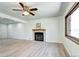 Bright living room features a cozy fireplace, ceiling fan, and a large window providing ample natural light at 6737 Lee St, Arvada, CO 80004