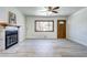 Open-concept living room with gray vinyl floors, fireplace, and natural light coming through the glass paneled front door at 6737 Lee St, Arvada, CO 80004