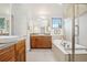 Bathroom featuring double vanity, soaking tub, and glass shower at 1511 S Pennsylvania St, Denver, CO 80210