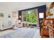 Bedroom with a crib, a chair, and a large window with natural light at 1511 S Pennsylvania St, Denver, CO 80210