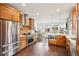 Gourmet kitchen features warm wood cabinets, stainless appliances, quartz countertops, and is open to the living room at 1511 S Pennsylvania St, Denver, CO 80210