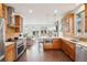 Gourmet kitchen features warm wood cabinets, stainless appliances, quartz countertops, and is open to the living room at 1511 S Pennsylvania St, Denver, CO 80210