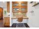 Functional office space with wood cabinetry, desk area, tile backsplash, and built-in cabinets at 1511 S Pennsylvania St, Denver, CO 80210