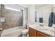 Bathroom with shower-tub combo, grey tiled wall and large vanity at 10121 Wyandott Cir, Thornton, CO 80260
