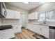 Well-lit kitchen featuring white cabinets, updated countertops, and plenty of storage space at 10121 Wyandott Cir, Thornton, CO 80260