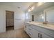 Bright bathroom featuring double sinks, a large mirror, and a walk-in closet at 11741 Magnolia St, Thornton, CO 80233
