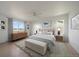 Bright bedroom with a neutral color scheme, a dresser, and bench at the foot of the bed at 11741 Magnolia St, Thornton, CO 80233