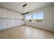 Bright dining area featuring a modern light fixture, white cabinets, and large windows at 11741 Magnolia St, Thornton, CO 80233