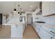 Bright, open kitchen with white cabinets, stainless appliances, and an island, leading to the staircase at 11741 Magnolia St, Thornton, CO 80233