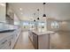 Spacious, all-white kitchen features stainless appliances, a central island, and views to the backyard at 11741 Magnolia St, Thornton, CO 80233
