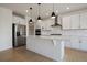 Modern kitchen with stainless steel appliances, white cabinets, and a large island with pendant lighting at 11741 Magnolia St, Thornton, CO 80233