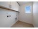 Functional laundry room with cabinetry for storage and a window with a view at 11741 Magnolia St, Thornton, CO 80233