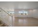 Open-concept living room with light wood floors, large windows, and plenty of natural light at 11741 Magnolia St, Thornton, CO 80233