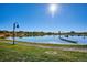 Picturesque lake view with a rowboat, grassy shoreline, and clear blue sky reflecting in the calm water, with trees in the background at 5128 W 26Th Ave # 311, Denver, CO 80212