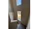 Carpeted staircase with white door and a window overlooking the yard at 8428 Galvani Trl # D, Littleton, CO 80129