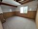 Unfinished basement with carpeting, wood paneling, and a single window at 22967 E Mineral Pl, Aurora, CO 80016