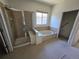 Bathroom featuring a glass-enclosed shower and a soaking tub with tile surround at 22967 E Mineral Pl, Aurora, CO 80016