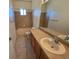 Well-lit bathroom featuring a bathtub with a shower, vanity with a sink, and a large mirror at 22967 E Mineral Pl, Aurora, CO 80016