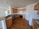 Well-lit kitchen featuring wood cabinets, stainless steel appliances, and hardwood flooring at 22967 E Mineral Pl, Aurora, CO 80016