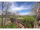 Scenic view of the golf course with a walking bridge surrounded by lush greenery and trees under a partly cloudy sky at 2685 S Dayton Way # 145, Denver, CO 80231