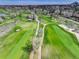 Expansive aerial shot of the golf course showcasing meticulously manicured fairways and greens surrounded by trees at 2685 S Dayton Way # 145, Denver, CO 80231