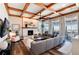 Spacious living room featuring a cozy sectional sofa and a fireplace with a stunning wooden beam ceiling at 27319 E Nova Cir, Aurora, CO 80016