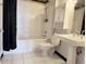 Bright bathroom featuring a shower-over-tub, white subway tile, pedestal sink, and white tile flooring at 1111 Osage St # 7, Denver, CO 80204