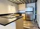Modern kitchen with black countertops, stainless steel refrigerator and light wood cabinets at 1111 Osage St # 7, Denver, CO 80204