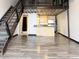 Open living space with metal stairs, hardwood floors, modern kitchen, and upstairs loft area at 1111 Osage St # 7, Denver, CO 80204